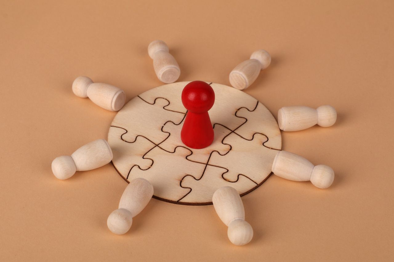 Service Wooden puzzle with a red pawn symbolizing leadership and teamwork dynamics.